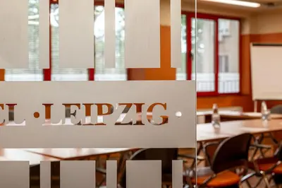 a sign in a classroom with tables and chairs at Hotel Leipzig in Plovdiv