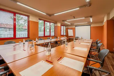 a conference room with a large wooden table and chairs at Hotel Leipzig in Plovdiv