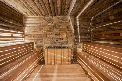 a sauna with wooden floors and a stone wall at Kashmir Wellness & SPA Hotel Adults Only in Velingrad