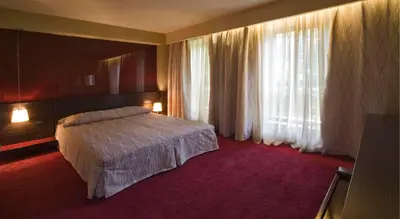 a hotel room with a bed and a large window at Famous House in Plovdiv