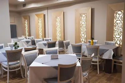 a dining room with white tables and chairs at Hotel BLVD 7 in Plovdiv