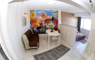 a living room with a painting of flowers on the wall at COLORED HOUSE Apartments in Sofia