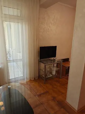 a living room with a television on a table and a window at Noviz Hotel in Plovdiv
