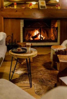 a living room with a fireplace with a table in front of it at Green Life Bansko in Bansko