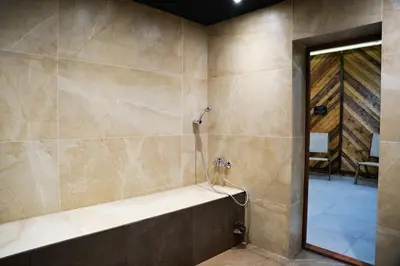 a bathroom with a shower with a tub at PM Services Flora Apartments in Borovets