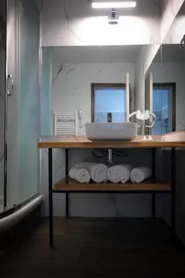 a bathroom with a sink and a shelf with towels at Snezhanka Hotel Pamporovo - Half Board & Swimming pool in Pamporovo