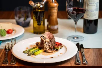 a plate of food on a table with a glass of wine at Four Points by Sheraton Bansko in Bansko