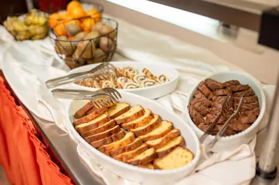 a buffet with three plates of food and desserts at Mura Hotel in Bansko