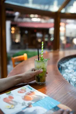 a hand holding a drink sitting on a table at Hotel Pirin SKI & SPA in Bansko