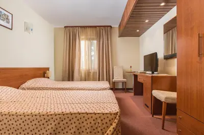 a hotel room with two beds and a television at Hotel Pirin SKI & SPA in Bansko