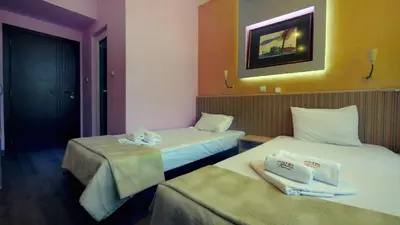 two beds in a hotel room with towels on them at Hotel Alabin Central in Sofia