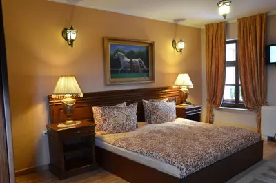 a bedroom with a bed with two lamps and a picture of horses at Boutique Hotel Boris Palace & Restaurant in Plovdiv