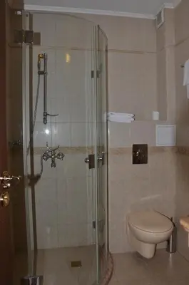 a bathroom with a toilet and a glass shower at Boutique Hotel Boris Palace & Restaurant in Plovdiv