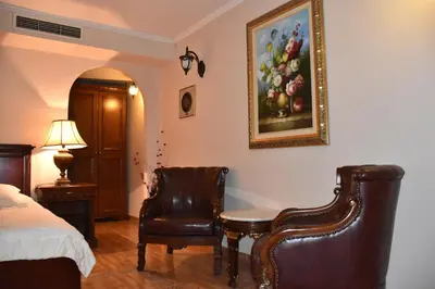 a bedroom with a bed and a chair and a picture of fruit at Boutique Hotel Boris Palace & Restaurant in Plovdiv