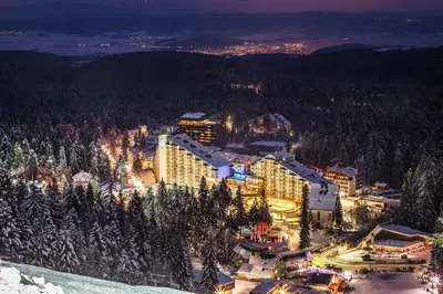 a resort in the mountains at night in the snow at Rila Hotel Borovets in Borovets