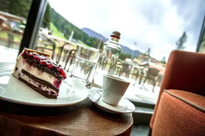 a piece of cake and a cup of coffee on a table at Rila Hotel Borovets in Borovets