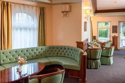 a living room with a green couch and chairs at Festa Winter Palace Hotel in Borovets