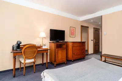 a hotel room with a desk with a television and a bed at Festa Winter Palace Hotel in Borovets