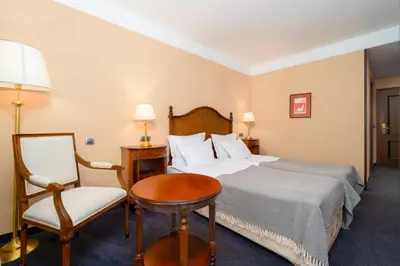 a hotel room with a bed and a chair at Festa Winter Palace Hotel in Borovets