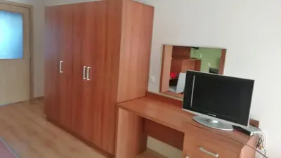 a television on a wooden dresser with a mirror at Pirin Place Bansko in Bansko