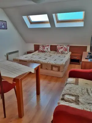 a room with two beds and a table and a couch at Pirin Place Bansko in Bansko