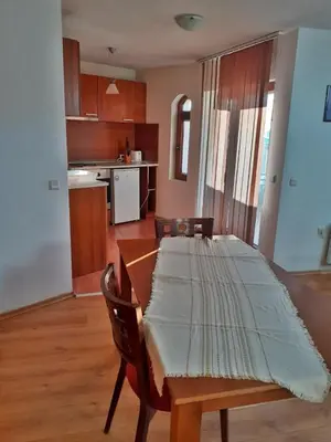 a dining room with a table and a kitchen at Pirin Place Bansko in Bansko