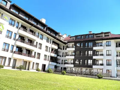 an apartment building with a lawn in front of it at Aparthotel Aspen in Bansko