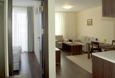 a living room and a living room with a kitchen and a living room at Aparthotel Aspen in Bansko