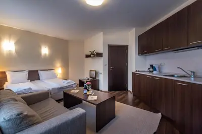 a living room with a couch and a bed at Aparthotel Aspen in Bansko