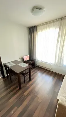 a living room with a table and a large window at Aparthotel Aspen in Bansko