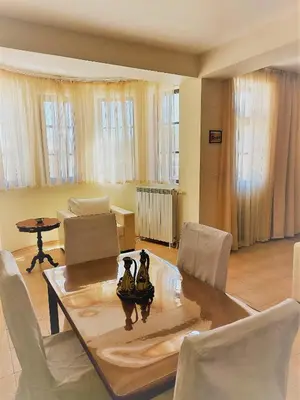 a living room with a dining room table and chairs at Pinerose Resort in Bansko