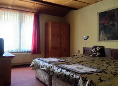 a bedroom with a bed and a large window at Family Hotel Santo Bansko in Bansko