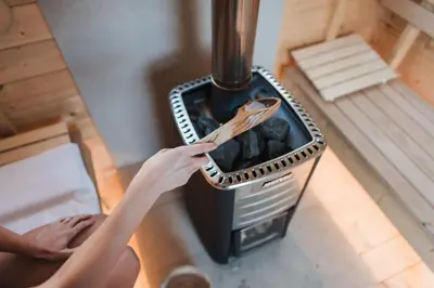 a woman holding a spatula next to a stove at Villas Jagoda & Malina in Borovets