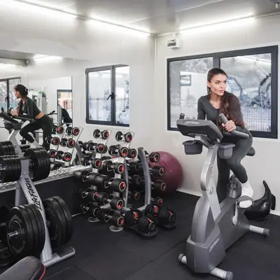 a woman riding on a treadmill in a gym at Villas Jagoda & Malina in Borovets
