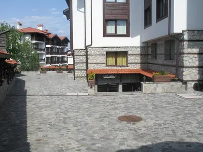 a building with a brick courtyard in front of it at Winslow Elegance Apartments in Bansko