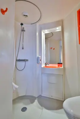 a white bathroom with a shower and a sink at easyHotel Sofia in Sofia