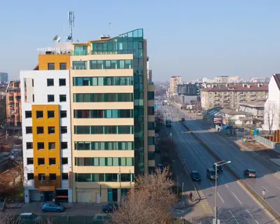 a tall building with glass windows on a city street at easyHotel Sofia in Sofia