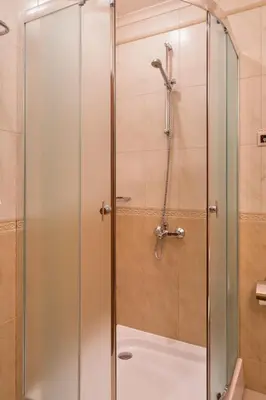 a shower with a glass door in a bathroom at Hotel Club Central in Hisarya