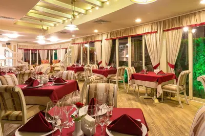 a restaurant with tables and chairs and red tablecloths at Hotel Club Central in Hisarya