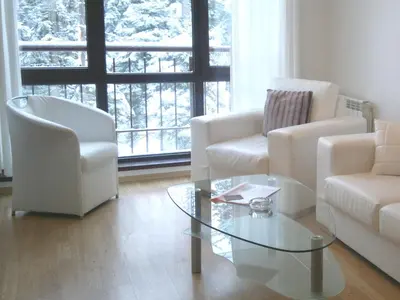 a living room with two chairs and a glass table at Persey Flora Apartments in Borovets