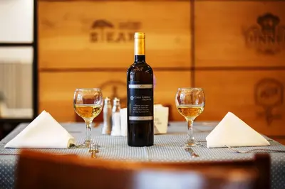 a bottle of wine sitting on a table with two glasses at Hotel Casa Karina Bansko - Half Board & All Inclusive in Bansko