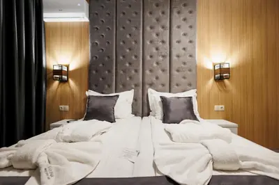 a bedroom with a large bed with white sheets and pillows at Hotel Casa Karina Bansko - Half Board & All Inclusive in Bansko