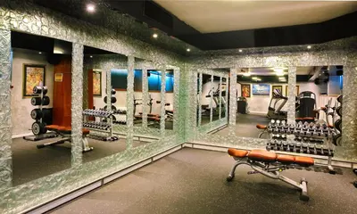 a room with a gym with a wall of mirrors at Hotel Anel in Sofia