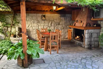 a patio with a table and chairs and a fireplace at Lina Hotel in Bansko