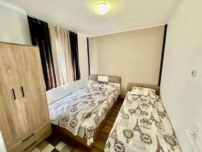 a small bedroom with two beds and a window at Villa Eti in Dospat