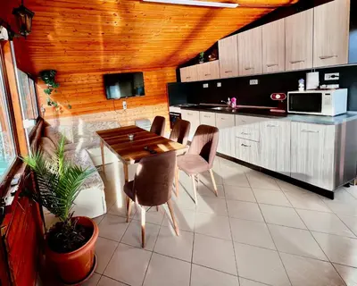 a kitchen with a table and chairs in a kitchen at Villa Eti in Dospat