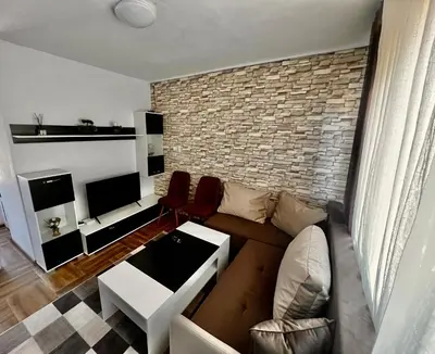 a living room with a couch and a brick wall at Villa Eti in Dospat