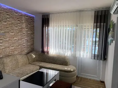 a living room with a couch and a brick wall at Villa Eti in Dospat