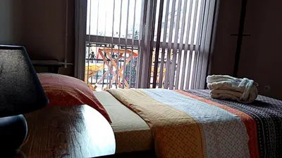 a bedroom with a bed with a blanket and a window at Guest House Fun and Rest in Plovdiv