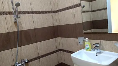 a bathroom with a sink and a shower with a mirror at Guest House Fun and Rest in Plovdiv